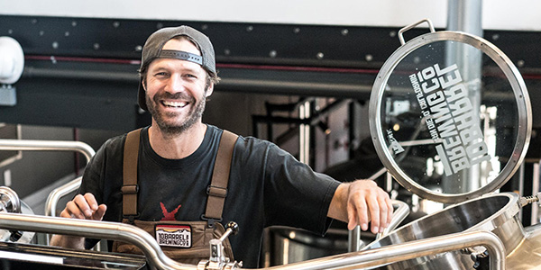 Photo of a smiling man working at a brewery